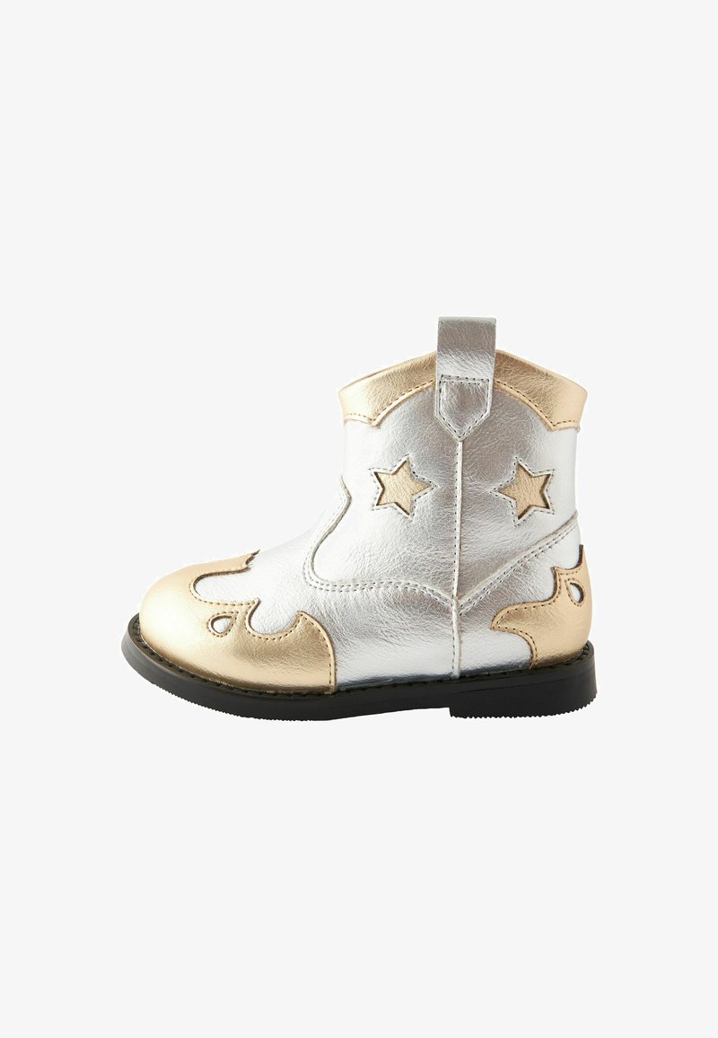 Stivale alla caviglia in pelle metallica argento e oro con ritagli a forma di stella, cuciture audaci e design decorativi. Suola in gomma nera.