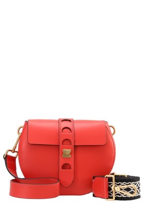 Rode leren crossbodytas met een gouden sluiting, decoratieve riem en een afneembare zwart-witte geweven schouderriem met goudkleurig beslag.