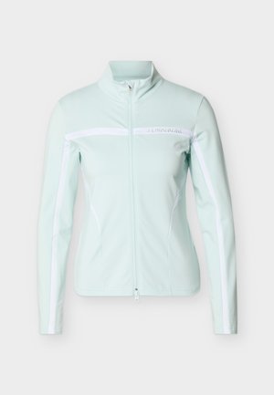 Γυναικείο ανοιχτό γαλάζιο μπουφάν με φερμουάρ πλήρους μήκους, λευκές ρίγες στα μανίκια και στο στήθος, γιακάς που στέκεται όρθιος και λογότυπο J.Lindeberg στην εμπρός δεξιά πλευρά.