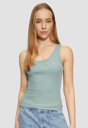 Light blue ribbed tank top with a scalloped lace trim at the neckline. The fabric is soft and fitted, paired with high-waisted denim shorts.