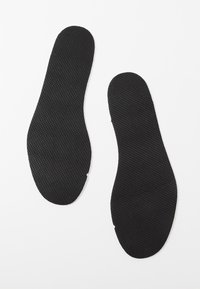 Plantillas negras con una superficie texturizada, diseñadas para mayor comodidad. Cada plantilla tiene una forma contorneada con bordes redondeados, adecuada para calzado.