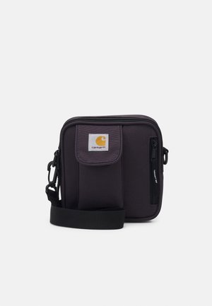 Sort crossbody-taske i stof med justerbar rem, frontlomme med klap, lynlås og Carhartt-logo. Kompakt og struktureret design.