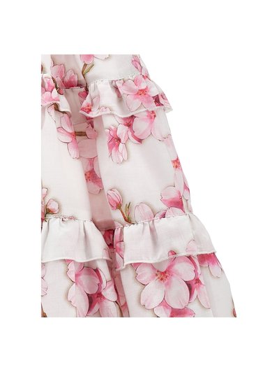 Vestido floral con un fondo blanco y patrones de flores rosas. El diseño incluye acentos con volantes en la parte inferior y en las mangas.