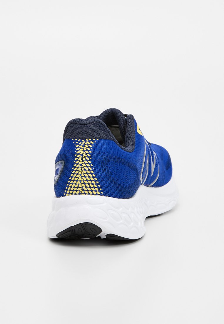 Zapatilla deportiva azul con una parte superior sintética texturizada, acentos amarillos y una suela blanca acolchada con un patrón de tracción.