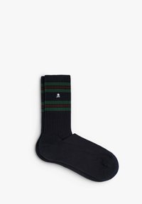 Calcetines negros con canalé que presentan rayas verdes y rojas en el puño y un logo de calavera blanca. Fabricados con un material suave y elástico.