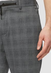 Grijze geruite broek van een textuurstof. Heeft een klassieke pasvorm, een verstelbare trekkoordtailleband en zijzakken.