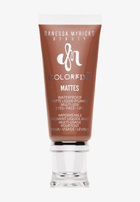 Tubo marrón de Danessa Myricks Beauty Colorfix Mattes, pigmento líquido mate waterproof para ojos, rostro y labios con tapa transparente.