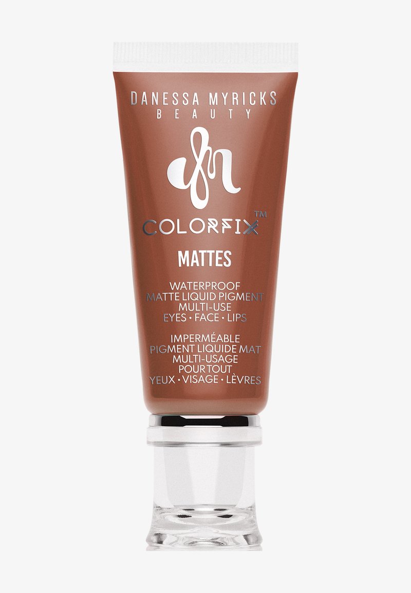 Tubo marrón de Danessa Myricks Beauty Colorfix Mattes, pigmento líquido mate waterproof para ojos, rostro y labios con tapa transparente.