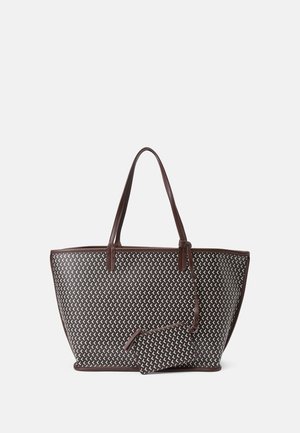 Grand sac cabas marron avec motif géométrique blanc, deux anses et petite pochette assortie attachée par une sangle sur un fond uni.