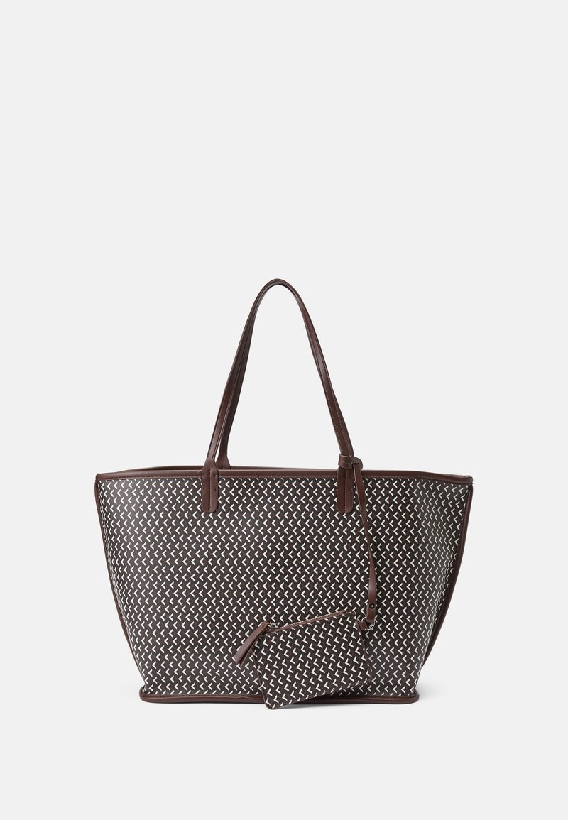 Grand sac cabas marron avec motif géométrique blanc, deux anses et petite pochette assortie attachée par une sangle sur un fond uni.