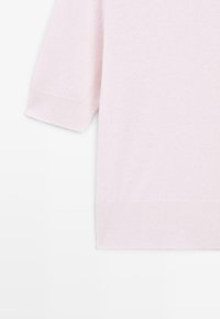 Maglione corto a maniche corte di colore rosa chiaro con polsini e orlo a coste, esposto su uno sfondo bianco.