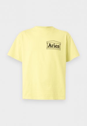 Ανοιχτό κίτρινο κοντομάνικο T-shirt με το κείμενο «Aries» μέσα σε απλό αρχιτεκτονικό πλαίσιο στο αριστερό στήθος.