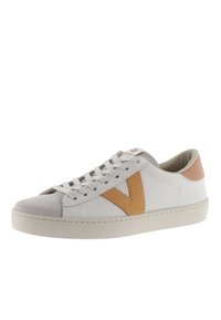 Zapatilla blanca con punta de ante gris, logotipo V de ante marrón y acentos de cuero. Incluye cordones planos y una suela suave y texturizada.