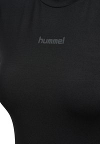 Sort tætsiddende t-shirt lavet af glat stof. Har en rund halsudskæring og et diskret, præget "hummel" logo på brystområdet.