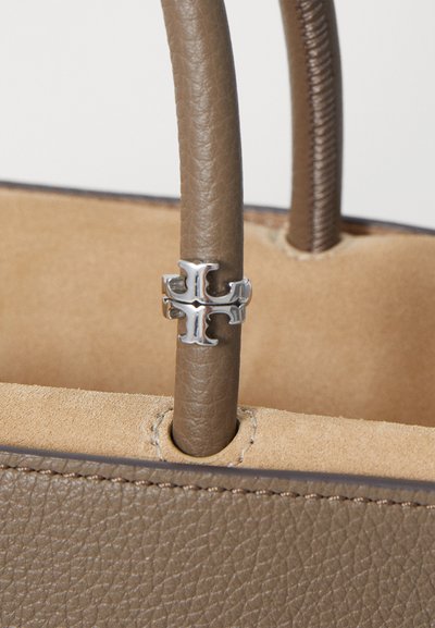 Sac à main en cuir brun avec une surface texturée, doté d'une poignée ronde lisse et d'un élément en argent à la base de la poignée.