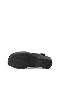 Sandal nero con suola in gomma testurizzata, forma curva e cinturino regolabile. La suola presenta scanalature orizzontali per una migliore trazione.