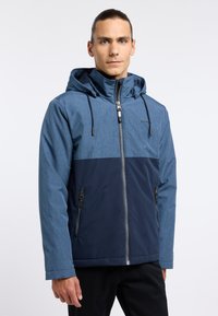 Giacca a vento da uomo con cappuccio, caratterizzata da una parte superiore blu melange e una parte inferiore blu navy, con chiusura frontale a zip e tasche laterali con zip.
