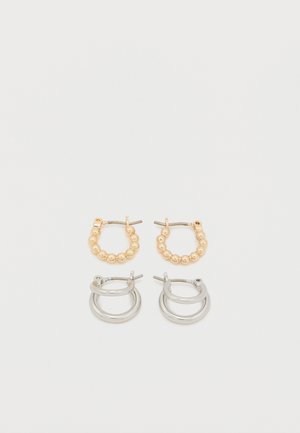 Gold and silver hoop earrings; gold features bead accents, silver has a smooth, polished finish; both have a classic hoop design.