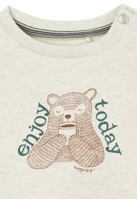 Katoenen T-shirt in crème met een bruine berenafbeelding die een mok vasthoudt, en de tekst "geniet vandaag" in teal, met een gestreepte kraagaccent.