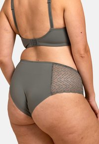 Culotte en dentelle grise au dos, avec un devant lisse, des détails en dentelle texturée au niveau des hanches et une taille élastique pour le confort.