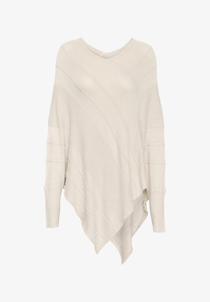 Poncho de color crema de punto con cuello en V, que presenta patrones de canalé diagonales y un dobladillo asimétrico. Textura suave y mangas largas.