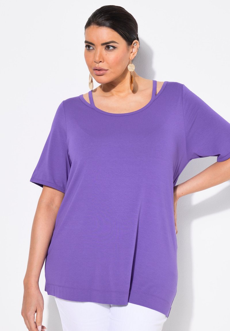 Lila t-shirt med kort ärm och rundad hals, med lager av band vid axlarna och en avslappnad passform. Slät textur och sidslitsar.