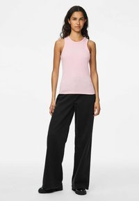 Top de tirantes de color rosa claro con cuello redondo, combinado con pantalones de pierna ancha de color negro. Textura suave, diseño minimalista, sin patrones prominentes.