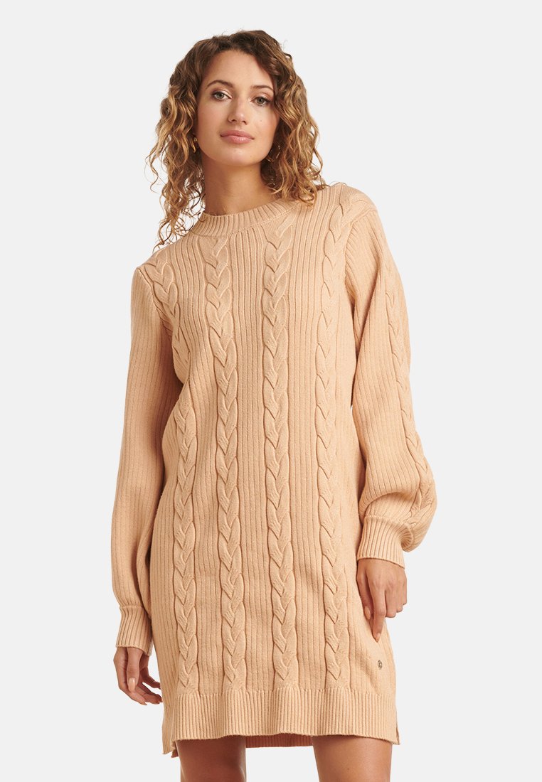 Vestito maglia in beige chiaro, caratterizzato da motivi a treccia, polsini a costine e una vestibilità comoda. Tessuto morbido, lunghezza fino al ginocchio.