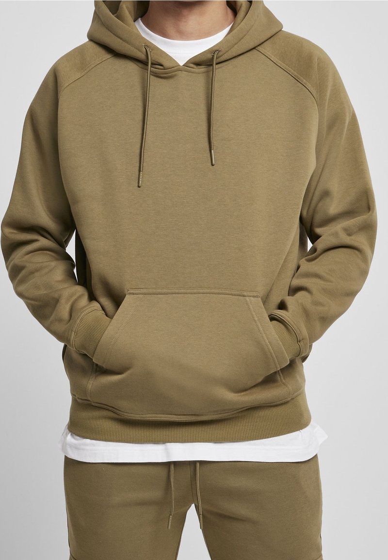 Khaki mikina s kapucí, vybavená prostornou přední kapsou, šňůrkami a žebrovanými manžetami. Měkká látka s pohodlným a volným střihem.