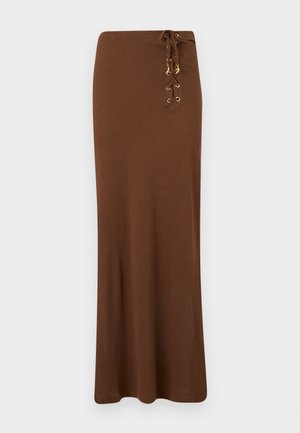 Μακριά καφέ φούστα με ψηλή μέση και λεπτομέρεια με κορδόνια που διαθέτει χρυσούς οφθαλμούς και γούρια στη δεξιά πλευρά.