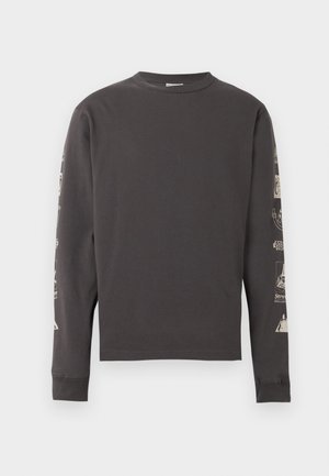 Sötétszürke, hosszú ujjú, kerek nyakú póló, fehér grafikákkal mindkét ujján, fehér háttér előtt.