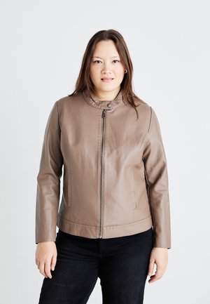 Veste en cuir marron avec un col montant, fermeture éclair à l'avant et poches latérales. Texture lisse et style ajusté, portée sur un pantalon noir.