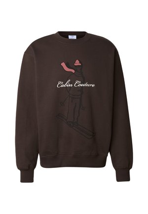 Hnědá mikina s potiskem lyžaře v růžové a černé barvě s nápisem "Cabin Couture." Měkká, texturovaná látka s žebrovanými manžetami.