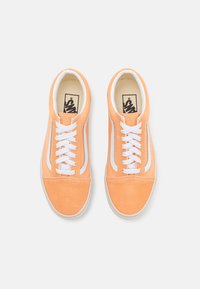 Oransje semskede sneakers med hvite snørebånd og sideakenter. Rund tå og flat såle, med et klassisk lavt design.