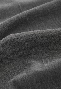 Tissu doux gris foncé avec une texture fine et des plis doux créant des vagues lisses et fluides à la surface.