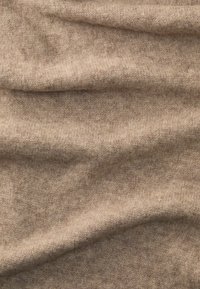 Soft, beige woolen fabric with fine knit texture and subtle folds creating gentle shadows and highlights.