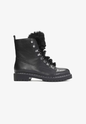 Black leather ankle boots with faux fur trim, silver hardware, and a rugged sole. Features lace-up design and round toe with textured surface.