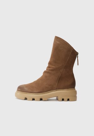 Bottine en cuir marron avec une finition texturée, fermeture éclair latérale et semelle en caoutchouc épaisse. Bout arrondi et conception supérieure flexible.