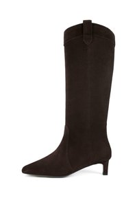 Stivale in suede marrone scuro, alto fino al ginocchio, con punta affusolata, tacco basso a kitten e un pratico linguetta nella parte superiore per facilitarne l'indossamento.