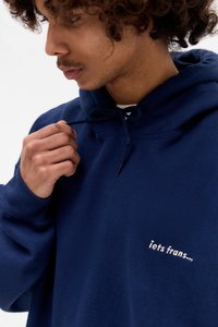 Felpa blu navy con cappuccio regolabile, caratterizzata da un piccolo testo ricamato in bianco che dice "iets frans..." sul davanti, realizzata in materiale di cotone.