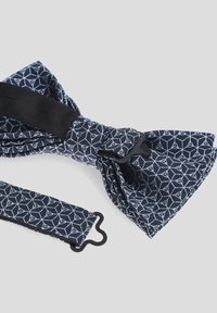 Granatowy muszka z geometrycznym wzorem w jasnym niebieskim kolorze, wykonana z materiału; posiada regulowany pasek i czarny zamek do zapięcia.