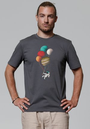 Grijze katoenen T-shirt met een astronaut die kleurrijke planetenballonnen vasthoudt. Het ontwerp is gecentreerd op de voorkant. Korte mouwen, ronde halsstijl.