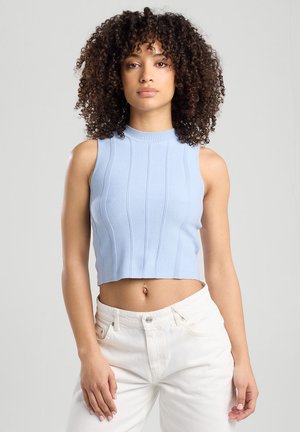Light blue cropped sleeveless top with ribbed texture and vertical stripes, paired with white high-waisted jeans.