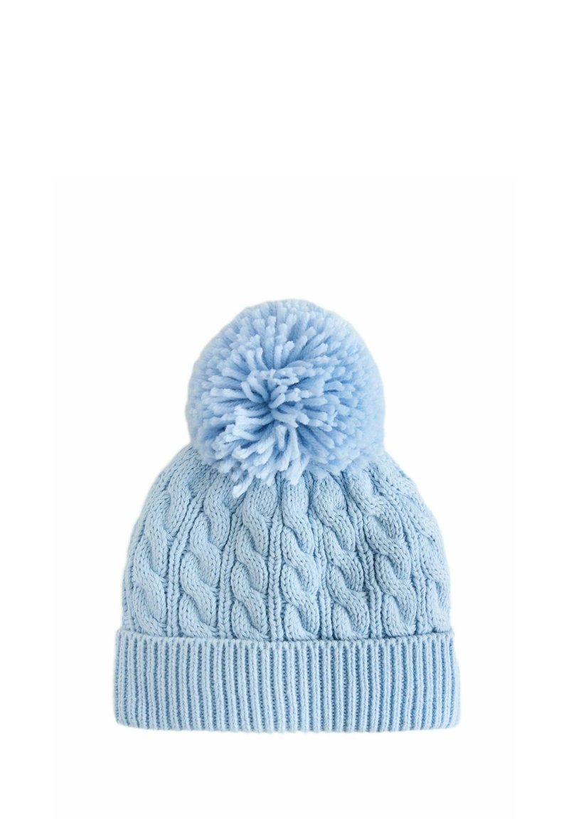 Bonnet tricoté bleu clair avec un grand pompon sur le dessus, présentant un motif de tricot à torsades et une bande texturée en bas.