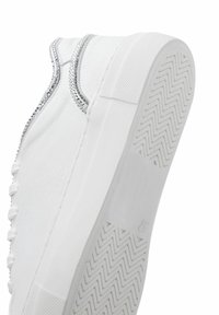 Valkoiset nahkasneakerit, joissa on sileä pinta, ja joissa on strassivivula reuna sekä kuvioitu kumipohja, jossa on kalanruotokuvio.