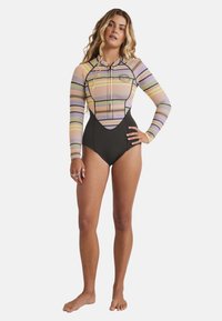 Long-sleeve swimsuit with multicolored horizontal stripes in pink, purple, yellow, and a black bottom; features a front zipper and logo detail.