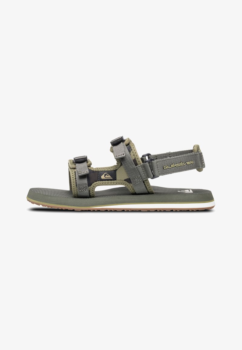 Green outdoor sandal with adjustable straps and cushioned footbed. Features durable plastic hardware and textured rubber sole for traction.