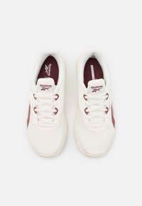 Vita Reebok-sneakers med maroon-accenter, med en meshdesign, snörning och en vadderad krage, visade från ovan mot en vit bakgrund.