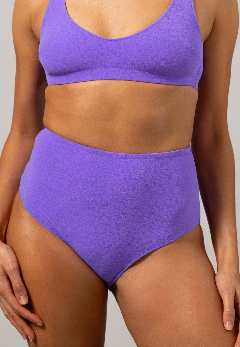 Lila bikini-set i strukturerad tyg; bralette-top med breda band, högmidjade bottnar, sömlös design, mjukt avslut.