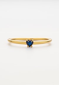 Goldring mit einem dünnen Band und einem herzförmigen blauen Edelstein, der in einer Vierkantfassung eingesetzt ist. Polierte Oberfläche ohne zusätzliche Textur.